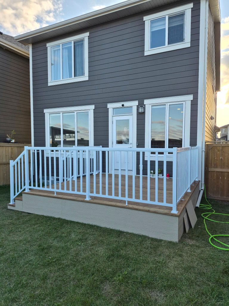 Rear wood deck with white railing on a Calgary home