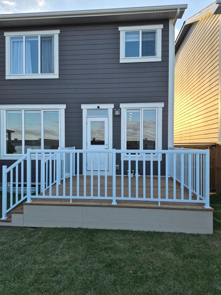 Raised wood deck with white aluminum railings
