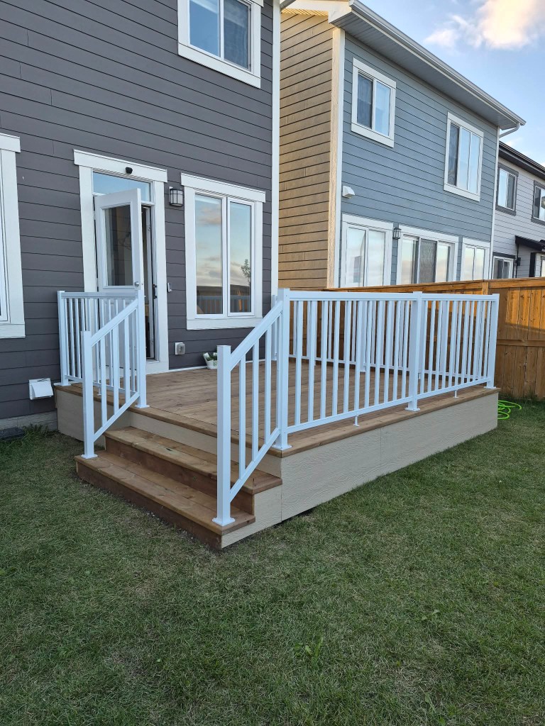 Wood deck stairs with white railing and skirting