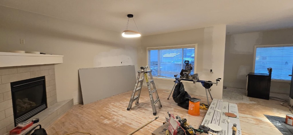 Living room renovation with fireplace, drywall, and finish carpentry