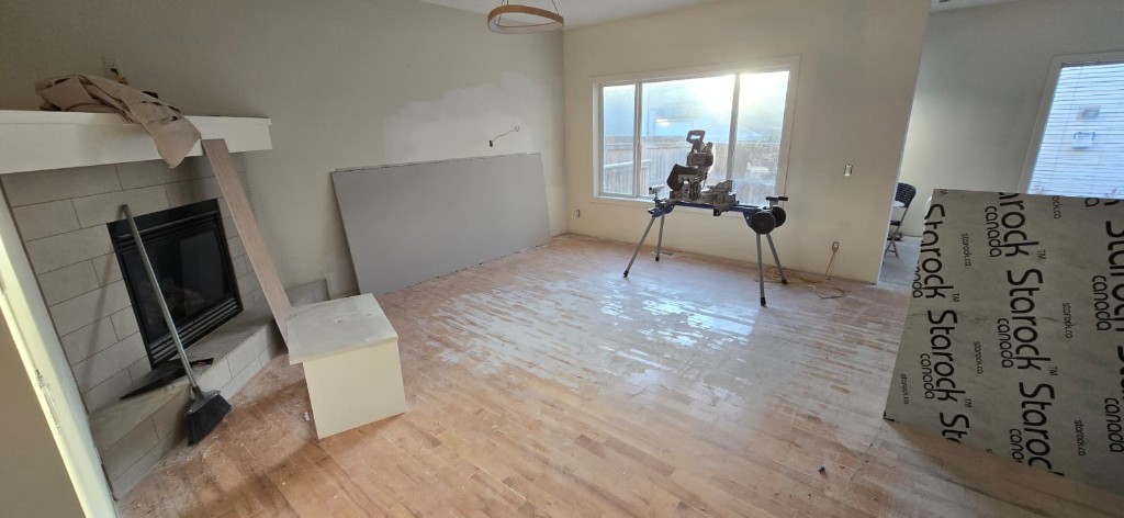 Open living room renovation with fireplace and hardwood floors