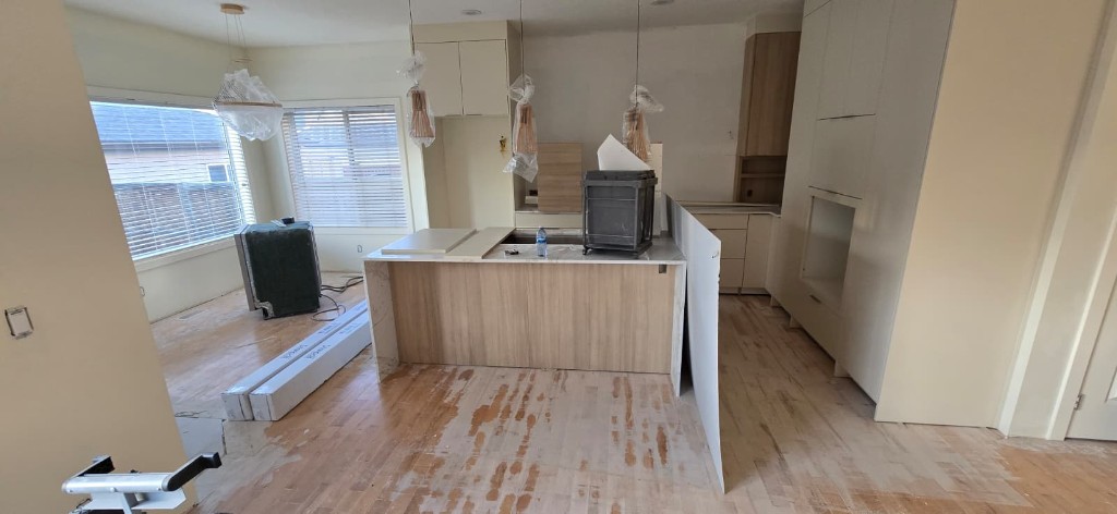 Kitchen island with stone waterfall countertop during renovation