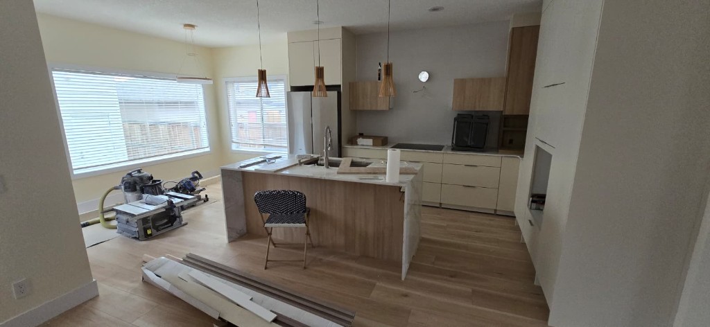 Kitchen remodel with island, cabinetry, and light hardwood flooring
