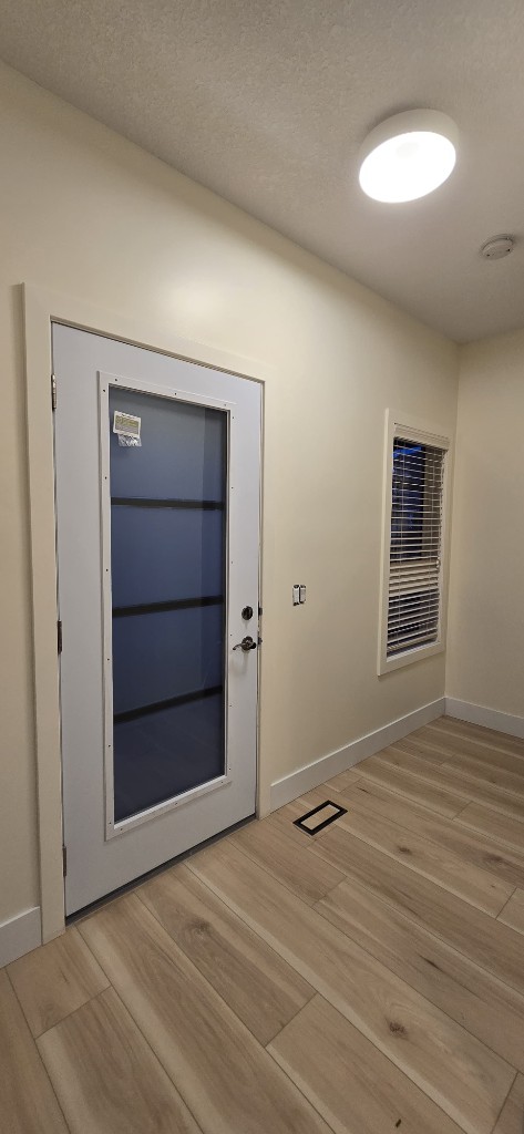 Interior glass entry door and hardwood flooring