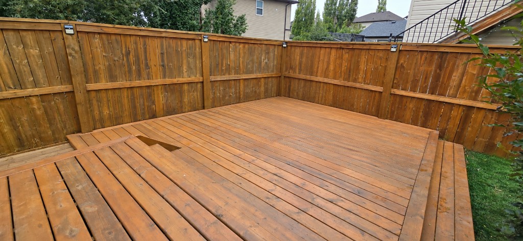 Stained cedar deck enclosed by a wood privacy fence